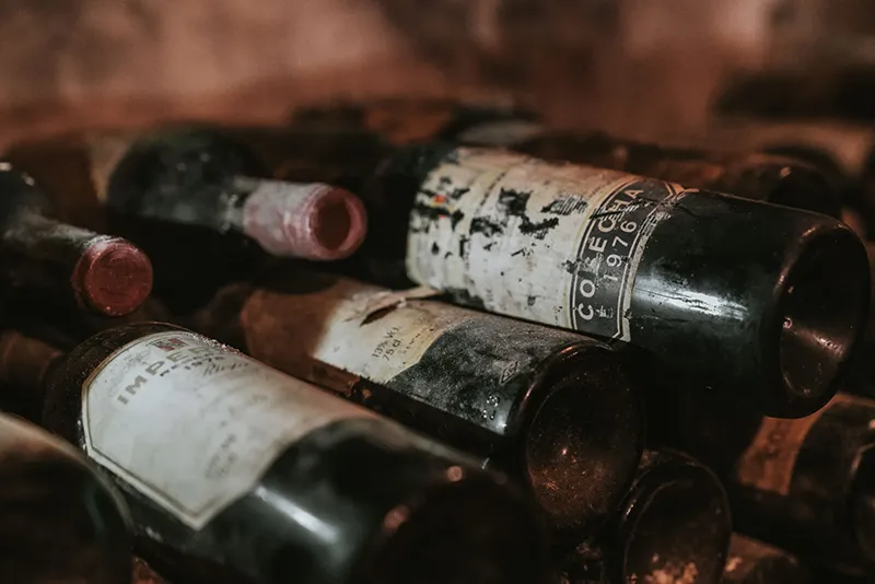 Botellas de vino envejecido almacenadas en la bodega de Asador Nicolás en Tolosa.