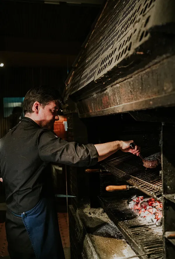 Xabi Ruiz cocinando una txuleta en la parrilla de carbón de Asador Nicolás en Tolosa.